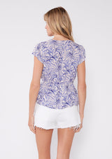 [Bone/Lilac] This top features a delicate floral and foliage print in shades of lilac on a bone-colored background. Made from lightweight fabric, it has a deep V-neckline with a small center keyhole detail, adding a hint of allure. The cap sleeves and gathered waistband create a flattering silhouette, making this top perfect for both casual and evening wear. Its nature-inspired charm is ideal for a spring or summer wardrobe.