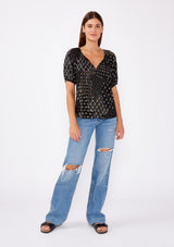 [Color: Black/Gold] A brunette model wearing a fall bohemian mixed floral print blouse with a split v neckline with ties and short buff sleeves. Features a partial button front for easy styling. A pretty fall top paired with denim jeans for a casual look.