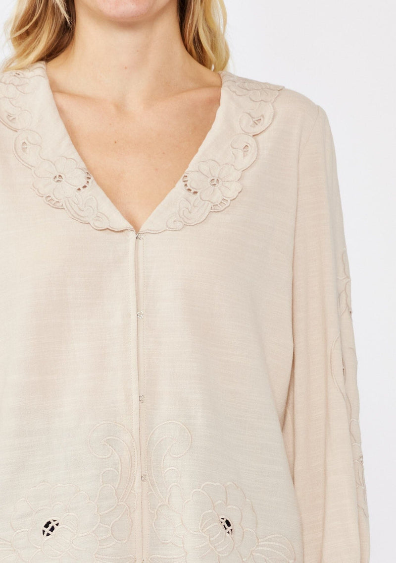 [Color: Buff] A blonde model wearing a beige blouse with a peter pan collar. A relaxed fit bohemian blouse with tonal embroidery, hook and eye front closure, long sleeves, and ruffle trim cuffs.