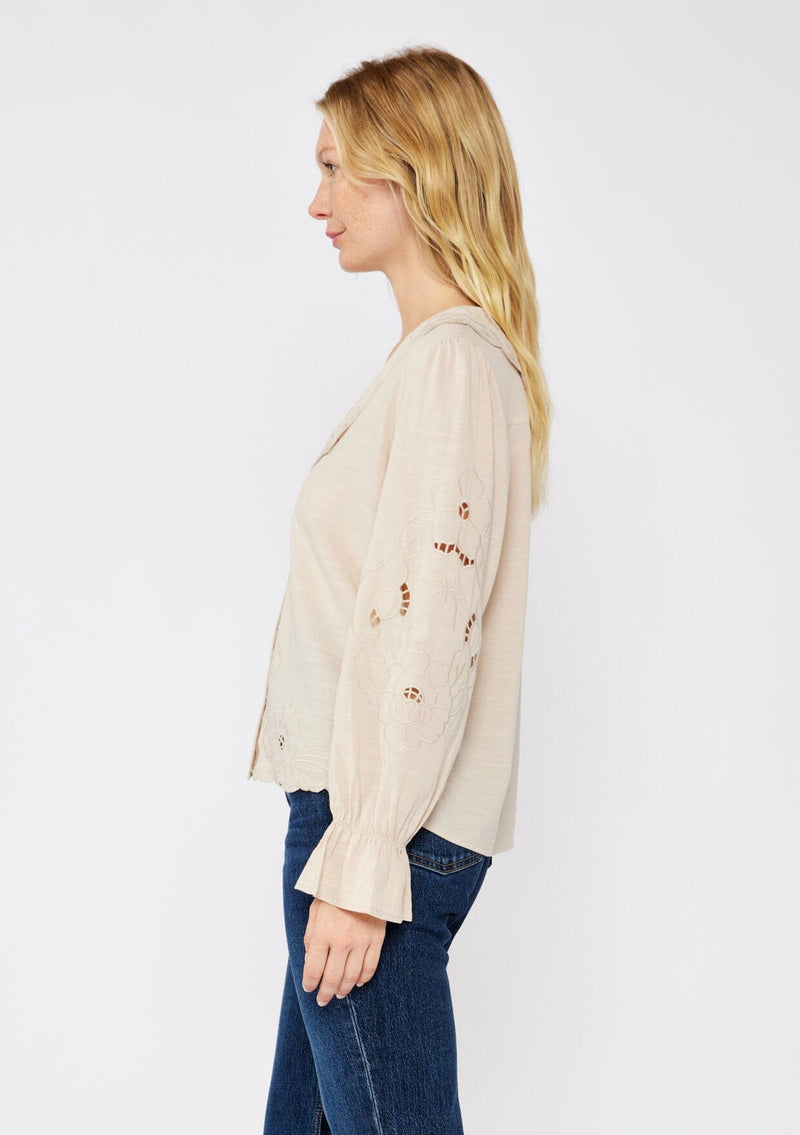 [Color: Buff] A blonde model wearing a beige blouse with a peter pan collar. A relaxed fit bohemian blouse with tonal embroidery, hook and eye front closure, long sleeves, and ruffle trim cuffs.