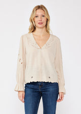 [Color: Buff] A blonde model wearing a beige blouse with a peter pan collar. A relaxed fit bohemian blouse with tonal embroidery, hook and eye front closure, long sleeves, and ruffle trim cuffs. 