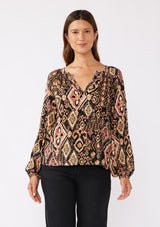 [Color: Grey/Dusty Rose] A front image of a brunette model wearing an ultra boho blouse with geometric ikat print in dusty pink and yellow. A casual fall blouse with a split v-neckline, long sleeves, and a relaxed fit. 