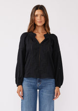 [Color: Black] A front facing image of a brunette model wearing a pretty boho blouse in a black. With floral tonal embroidery, lace trim inserts, long sleeves with smocked wrist cuffs, and a split v neckline. An airy and relaxed fit blouse crafted in a cotton blend fabric.