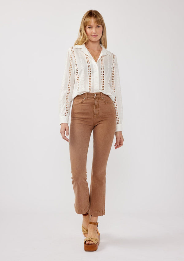 [Color: White] A front facing image of a blonde model wearing floral eyelet shirt with a collared neckline, button front, and long sleeves with button cuffs. A sophisticated spring top paired with brown denim bottoms for spring. 