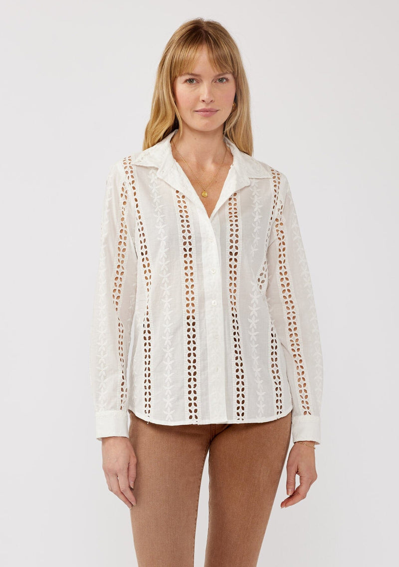 [Color: White] A front facing image of a blonde model wearing floral eyelet shirt with a collared neckline, button front, and long sleeves with button cuffs. A sophisticated spring top paired with brown denim bottoms for spring. 