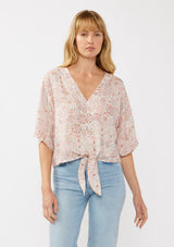 [Color: Natural/Dusty Pink] A front facing image of a blonde model wearing a pink bohemian print blouse with a v-neckline, tie front detail at the hem, and flowy kimono sleeves. Perfect for resort styling and casual outings. 