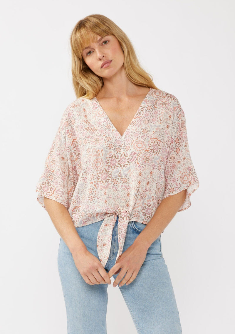 [Color: Natural/Dusty Pink] A front facing image of a blonde model wearing a pink bohemian print blouse with a v-neckline, tie front detail at the hem, and flowy kimono sleeves. Perfect for resort styling and casual outings. 