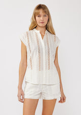 [Color: White] A front facing image of a blonde model wearing a white striped eyelet embroidered camp shirt with a button front and short dolman sleeves. Styled for the beach and a resort vacation getaway. 