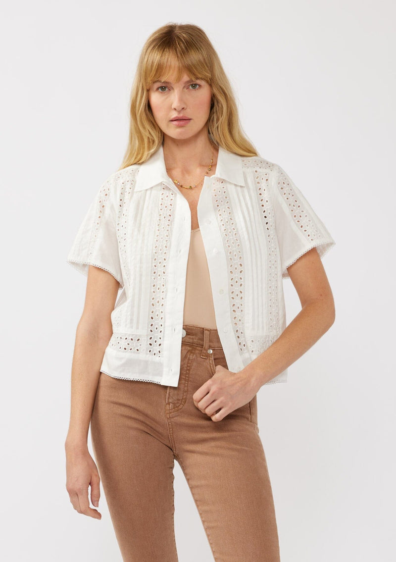 [Color: White] A front image of a blonde model wearing a white floral eyelet shirt in a cropped length. This unbuttoned shirt features a button front, collared neckline, pintuck details, and picot trim. The perfect resort top for layering. 