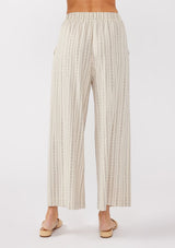 [Color: Natural/Black] A back image of a model wearing beige cotton-blend pants with black yarn-dyed stripes. The pants feature an elastic waistband, wide legs, and a cropped hem, making them perfect for vacation, lounging, or a beach cover-up.