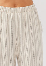 [Color: Natural/Black] A detail image of a model wearing beige cotton-blend pants with black yarn-dyed stripes. The pants feature an elastic waistband, wide legs, and a cropped hem, making them perfect for vacation, lounging, or a beach cover-up.