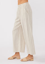 [Color: Natural/Black] A side image of a model wearing beige cotton-blend pants with black yarn-dyed stripes. The pants feature an elastic waistband, wide legs, and a cropped hem, making them perfect for vacation, lounging, or a beach cover-up.