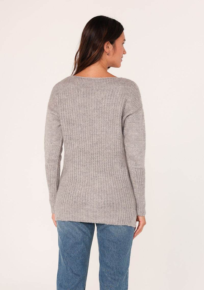 [Color: Heather Grey] A back facing image of a brunette model wearing a high neckline pullover sweater with long sleeves and ribbed details. 