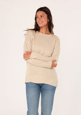 [Color: Natural] A side facing image of a brunette model wearing a high neckline pullover sweater with long sleeves and ribbed details. 