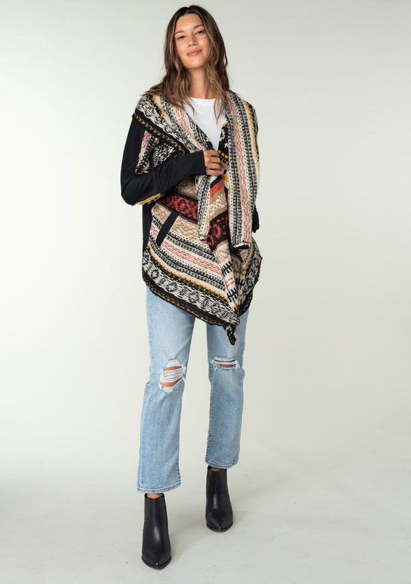 [Color: Black Multi] A brunette model wearing a fall southwestern stripe knit cardigan with long sleeves, a cozy shawl collar, and side pockets. Perfect for fall styling and elevating any boho wardrobe. 