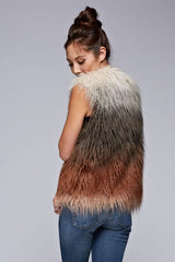 [Color: Vanilla/Grey/Rust] A side facing image of a brunette model wearing a ultra chic bohemian faux fur vest with an ombre design. 