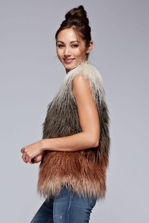 [Color: Vanilla/Grey/Rust] A side facing image of a brunette model wearing a ultra chic bohemian faux fur vest with an ombre design. 