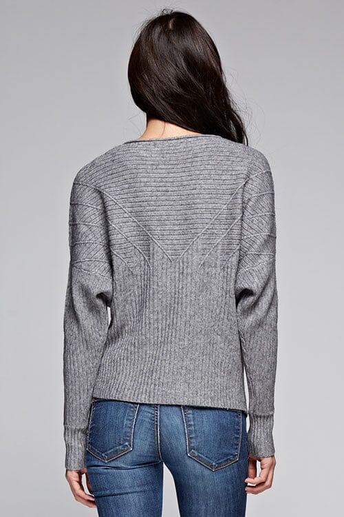 [Color: Heather Grey] A back facing image of a brunette model wearing a grey ribbed sweater with cozy long dolman sleeves. 