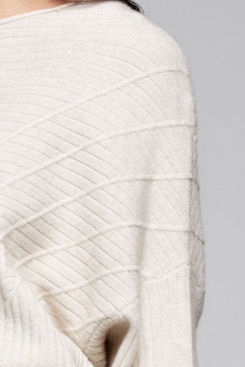 [Color: Oatmeal] A detail image of a brunette model wearing an off white ribbed sweater with cozy long dolman sleeves. 