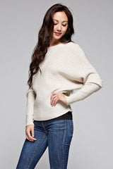 [Color: Oatmeal] A front facing image of a brunette model wearing an off white ribbed sweater with cozy long dolman sleeves. 