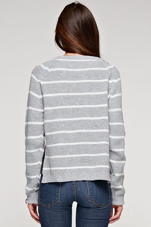 [Color: Heather Grey/Ivory] A brunette model wearing a stripe knit pullover sweater with long sleeves, a  crew neckline, and side vents. The perfect throw on for casual outings. 