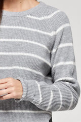 [Color: Heather Grey/Ivory] A brunette model wearing a stripe knit pullover sweater with long sleeves, a  crew neckline, and side vents. The perfect throw on for casual outings. 