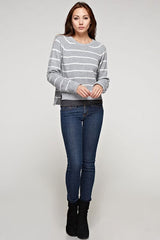 [Color: Heather Grey/Ivory] A brunette model wearing a stripe knit pullover sweater with long sleeves, a  crew neckline, and side vents. The perfect throw on for casual outings. 