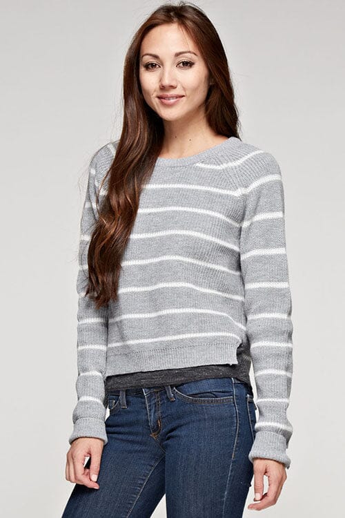 [Color: Heather Grey/Ivory] A brunette model wearing a stripe knit pullover sweater with long sleeves, a  crew neckline, and side vents. The perfect throw on for casual outings. 