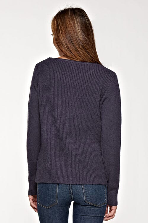 [Color: Graphite] A back facing image of a brunette model wearing a cozy ribbed knit sweater with a geometric design and a round neckline. 