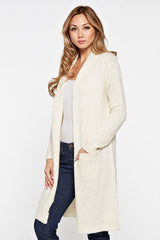 [Color: Vanilla] A blonde model wearing a cream ivory cardigan with a shawl collar, patch pockets, and a distressed back detail. 