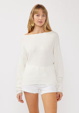 [Color: Winter White] A front facing image of a blonde model wearing a white waffle knit pullover sweater. With long sleeves, a relaxed fit, and a wide neckline that can be worn off the shoulder.