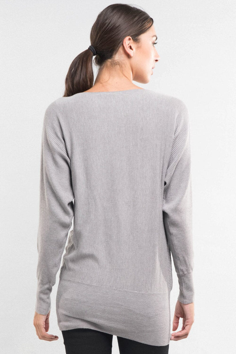 [Color: Heather Ash] A back facing image of a brunette model wearing a relaxed fit pullover grey sweater with long dolman sleeves, a round neckline, and a fitted hem. A long torso sweater perfect for casual outings and lounging. 