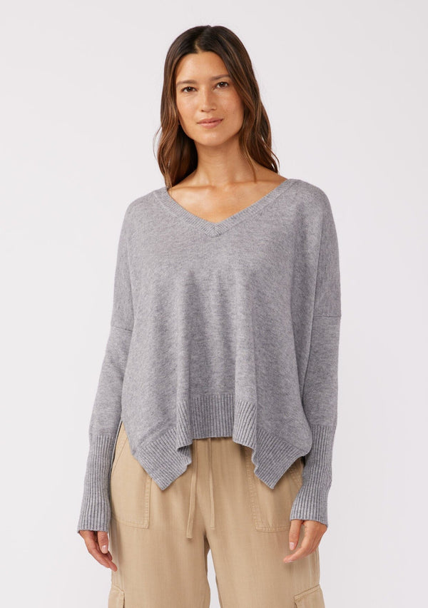 [Color: Lt. Heather Grey] A front facing image of a brunette model wearing a soft and relaxed fit knit sweater. A cozy fall pullover sweater with a boxy silhouette, v neckline, ribbed trim, and side vents. 