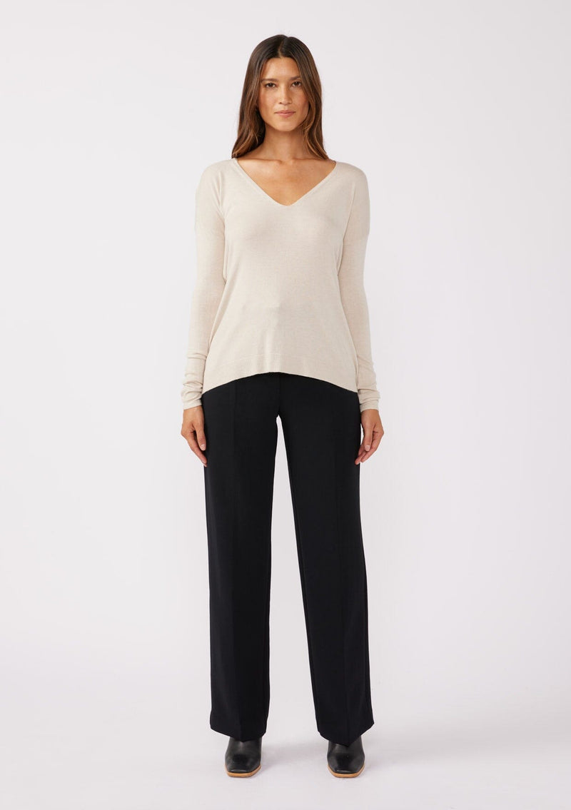 [Color: Bone] A full body front facing image of a brunette model wearing a soft  knit pullover sweater in ivory. With a comfortable v neckline, long sleeves, and an open back with surplice accent. The perfect basic knit top for any season. 