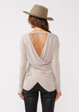 [Color: Heather Cement] A back facing image of a brunette model wearing a soft knit pullover sweater in taupe. With a comfortable v neckline, long sleeves, and an open back with surplice accent. The perfect basic knit top for any season. 