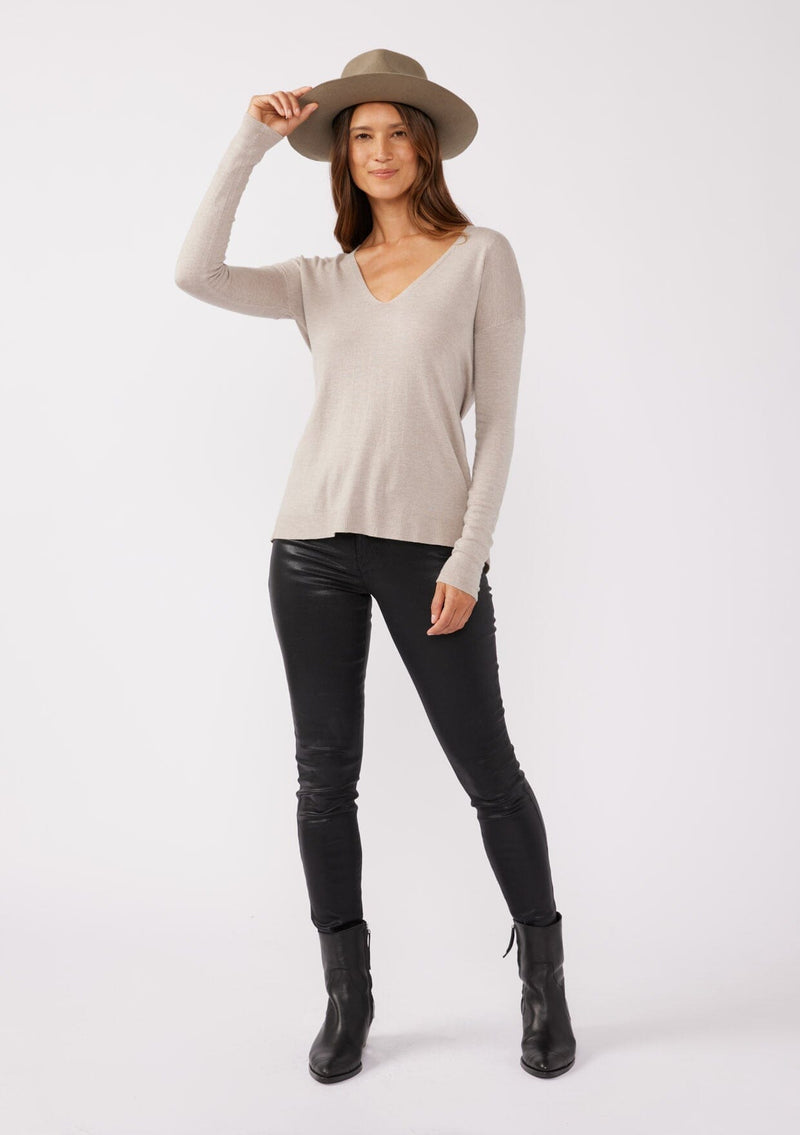 [Color: Heather Cement] A full body front facing image of a brunette model wearing a soft knit pullover sweater in taupe. With a comfortable v neckline, long sleeves, and an open back with surplice accent. The perfect basic knit top for any season. 