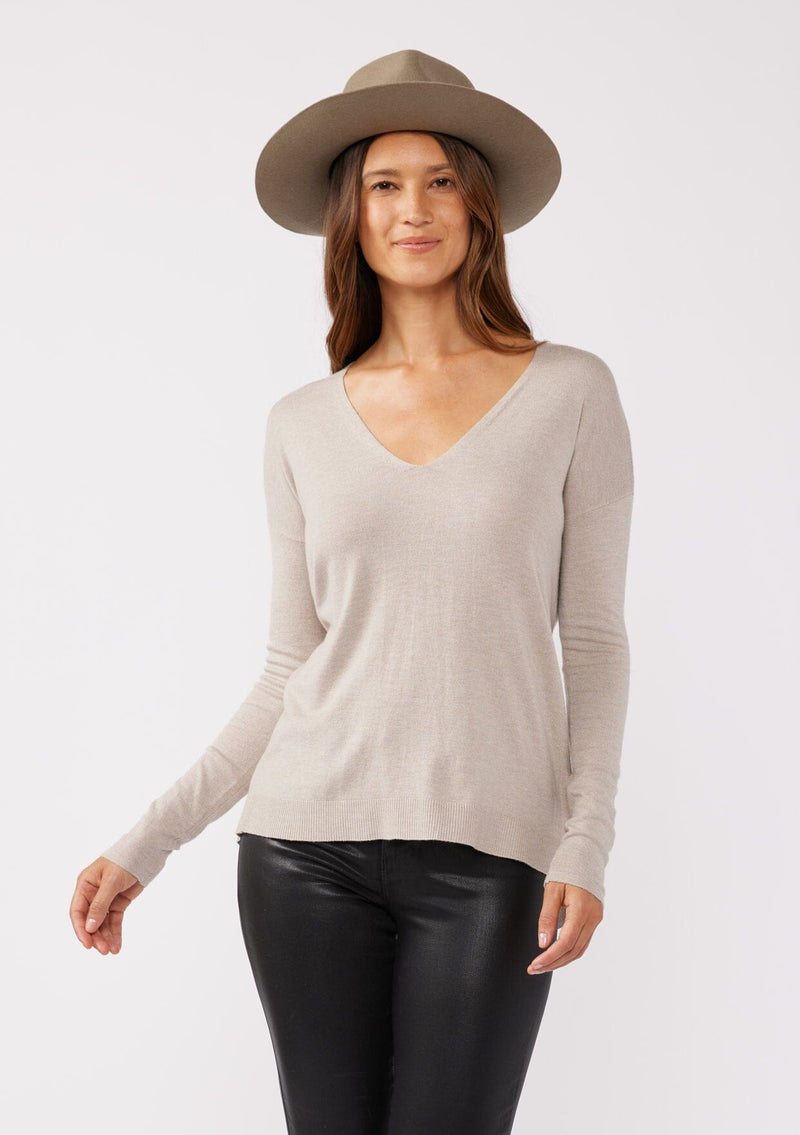 [Color: Heather Cement] A front facing image of a brunette model wearing a soft knit pullover sweater in taupe. With a comfortable v neckline, long sleeves, and an open back with surplice accent. The perfect basic knit top for any season. 