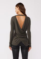 [Color: Hunter] A back facing image of a brunette model wearing a soft  knit pullover sweater in dark green. With a comfortable v neckline, long sleeves, and an open back with surplice accent. The perfect basic knit top for any season. 