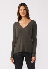 [Color: Hunter] A front facing image of a brunette model wearing a soft knit pullover sweater in dark green. With a comfortable v neckline, long sleeves, and an open back with surplice accent. The perfect basic knit top for any season. 