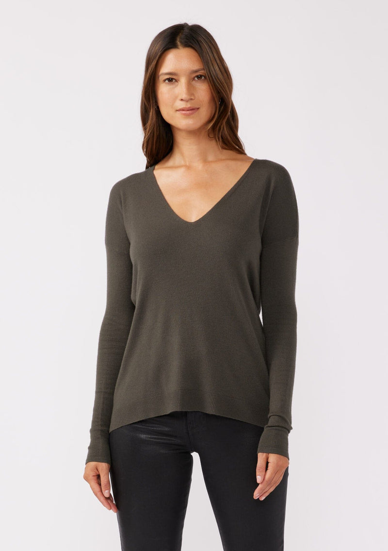 [Color: Hunter] A front facing image of a brunette model wearing a soft knit pullover sweater in dark green. With a comfortable v neckline, long sleeves, and an open back with surplice accent. The perfect basic knit top for any season. 