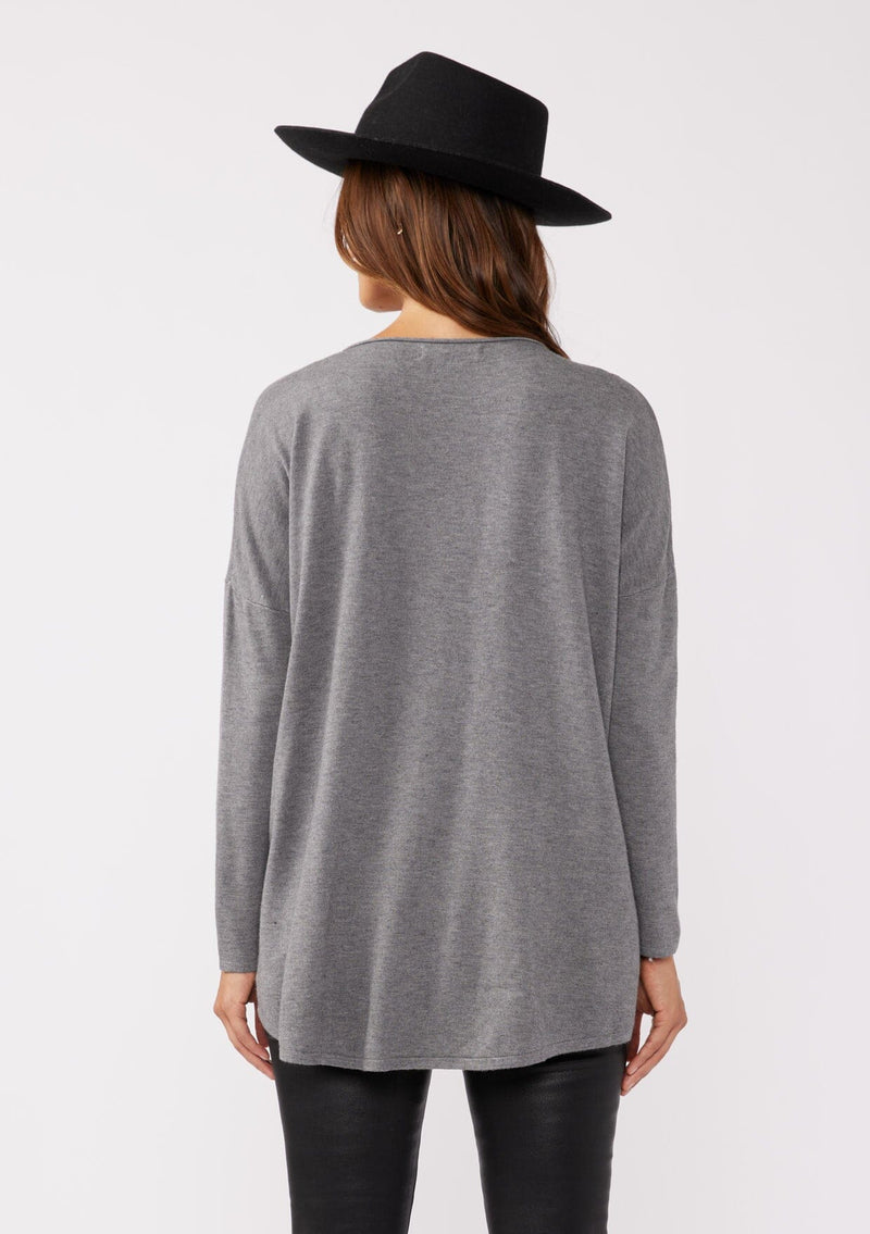 [Color: Heather Charcoal] A grey pocket pullover in a soft knit, featuring breezy side vents, an effortlessly chic rolled crew neckline, and two side pockets. Styled with a black mini dress and black boots for the Fall season. 