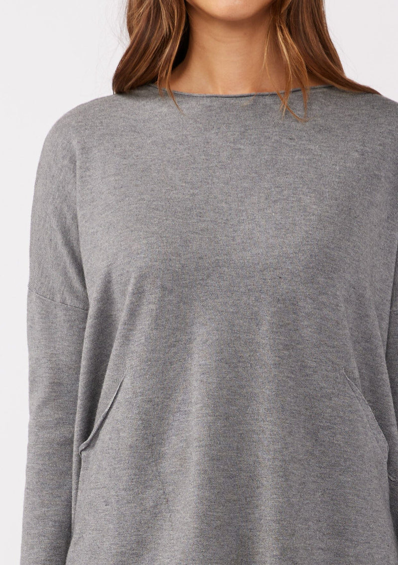 [Color: Heather Charcoal] A grey pocket pullover in a soft knit, featuring breezy side vents, an effortlessly chic rolled crew neckline, and two side pockets. Styled with a black mini dress and black boots for the Fall season. 