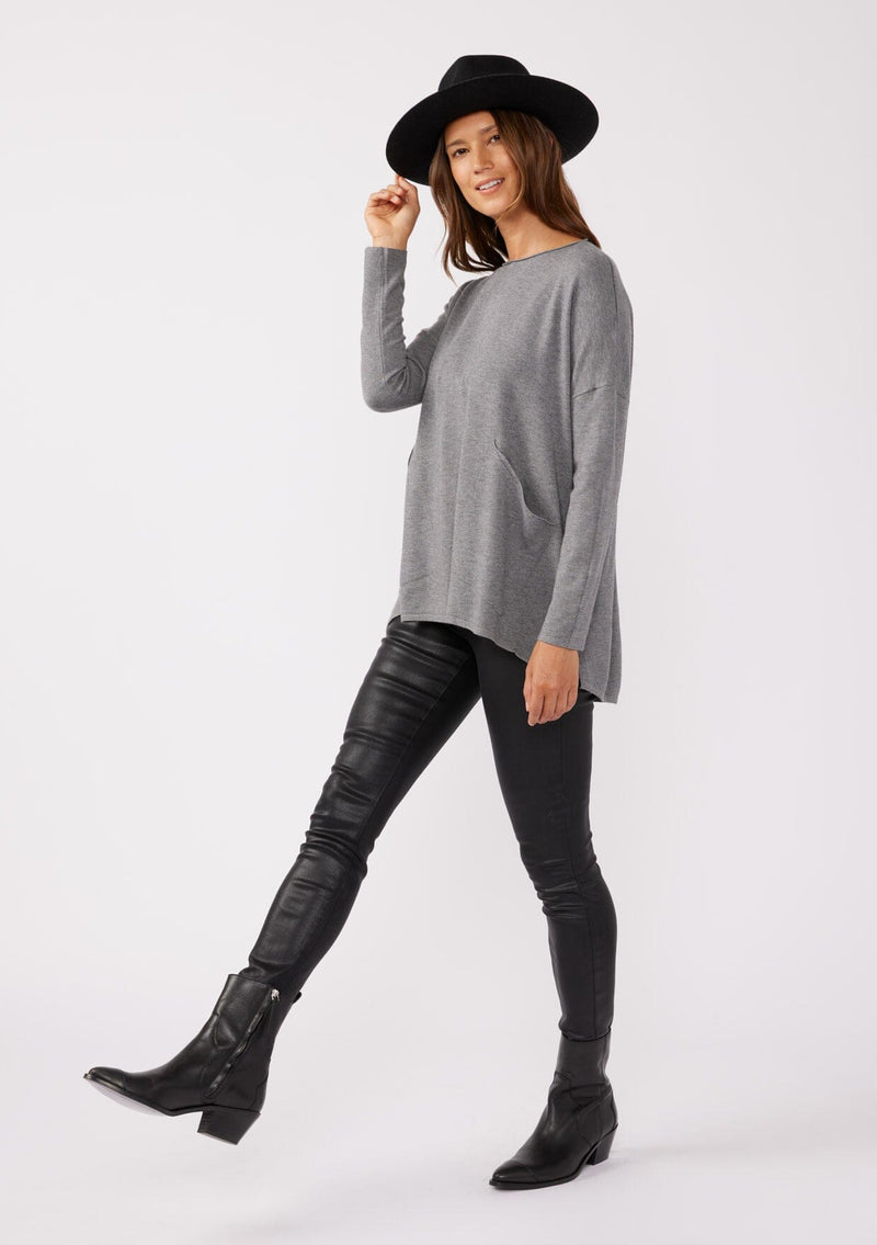 [Color: Heather Charcoal] A grey pocket pullover in a soft knit, featuring breezy side vents, an effortlessly chic rolled crew neckline, and two side pockets. Styled with a black mini dress and black boots for the Fall season. 