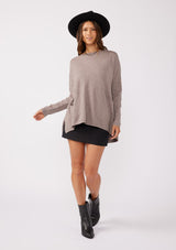 [Color: Heather Coco] A soft knit pocket pullover, featuring breezy side vents, an effortlessly chic rolled crew neckline, and two side pockets. Styled with a black mini dress and black boots for the Fall season. 