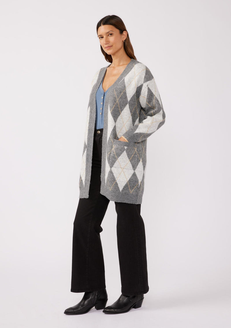 [Color: Charcoal/Grey] A side facing image of a brunette model wearing an ultra-soft mid length cardigan in a grey and light grey argyle plaid pattern. With long sleeves, an open front, and side pockets.