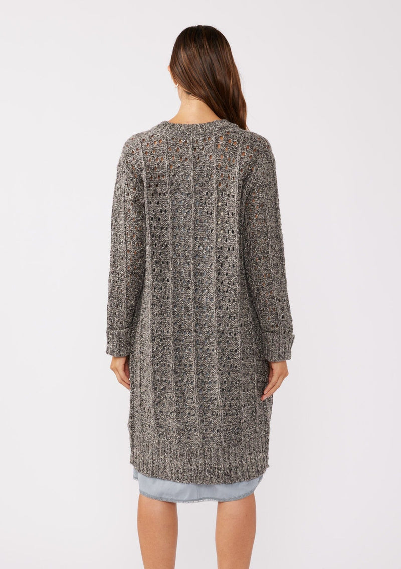 [Color: Charcoal] A back facing image of a brunette model wearing a dark charcoal grey open knit cardigan sweater. A mid length lightweight cardigan with long sleeves, an open front, and ribbed wrist cuffs.