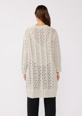 [Color: Oatmeal] A back facing image of a brunette model wearing an oatmeal open knit cardigan sweater. A mid length lightweight cardigan with long sleeves, an open front, and ribbed wrist cuffs.