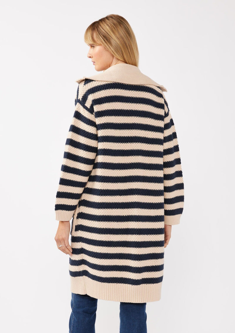 [Color: Navy/Natural] A back facing image of a blonde model wearing a mid length cardigan in a black and white stripe. With long sleeves, a collared neckline, an open front, and side pockets.