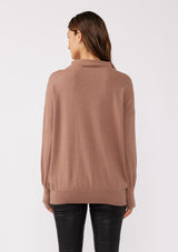 [Color: Chestnut] A back facing image of a brunette model wearing a brown cozy lightweight pullover with a mock neckline. Complete with long sleeves, dropped shoulders, and a snugged ribbed trim. Perfect for layering or styling on its own for a relaxed, laid-back fall look. 