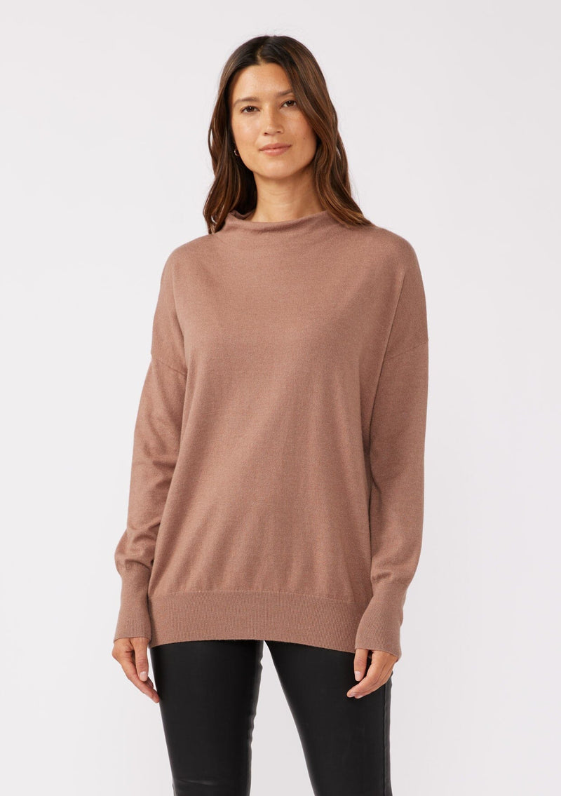 [Color: Chestnut] A front facing image of a brunette model wearing a brown cozy lightweight pullover with a mock neckline. Complete with long sleeves, dropped shoulders, and a snugged ribbed trim. Perfect for layering or styling on its own for a relaxed, laid-back fall look. 